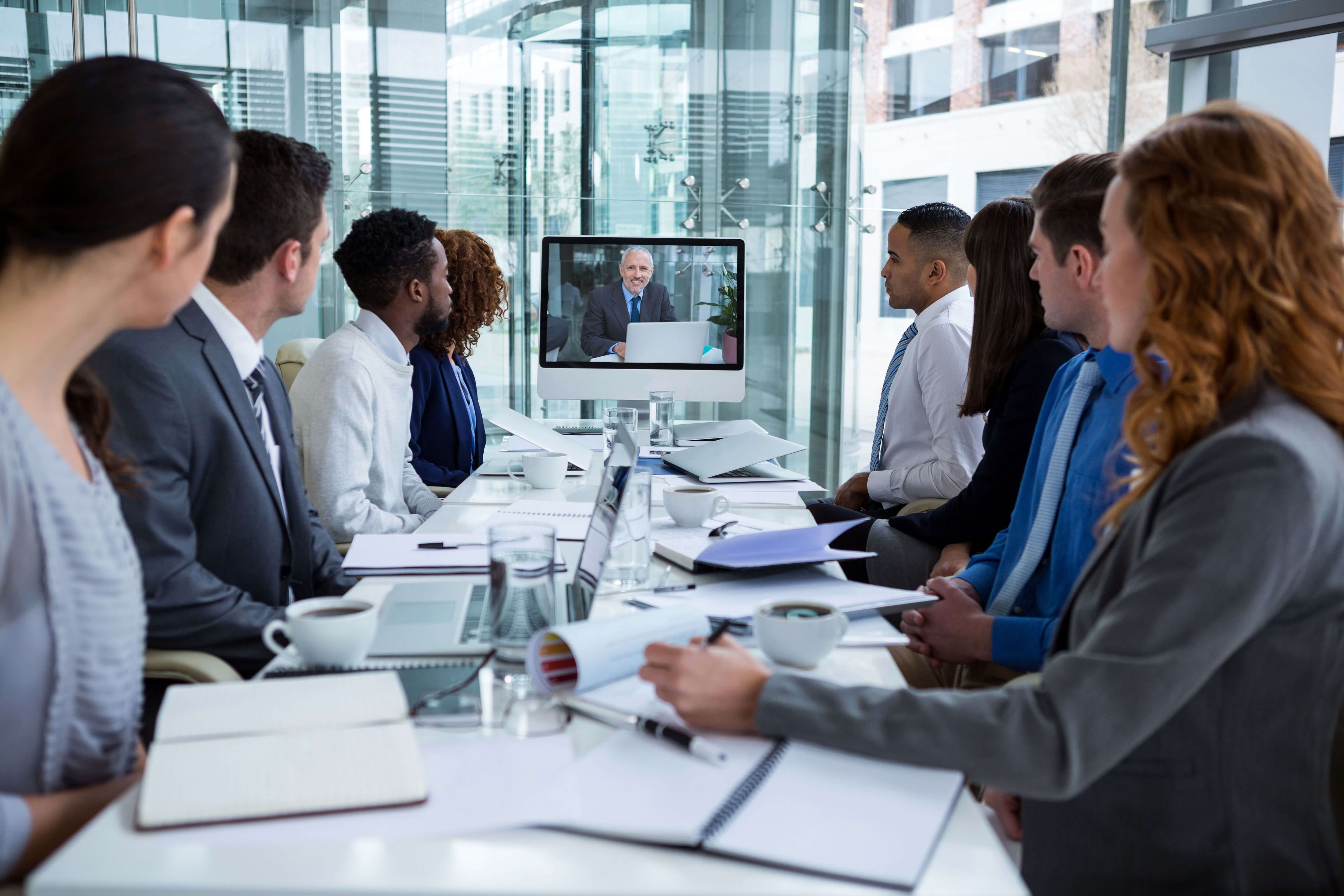 Work colleagues looking at screen and watching video presentation - Tips for working with video in PowerPoint - Image