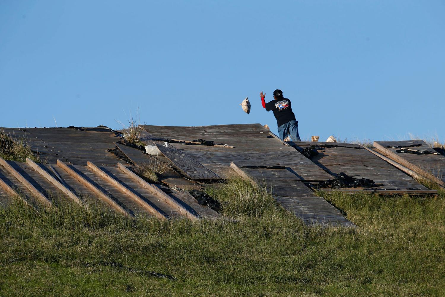 Workers throw sandbags and lay tarps to prevent further erosion of the slide on the dam. Corps of Engineers officials say a more permanent fix would cost between $50 million and $500 million.