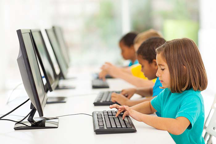 Young children working on desktop computers