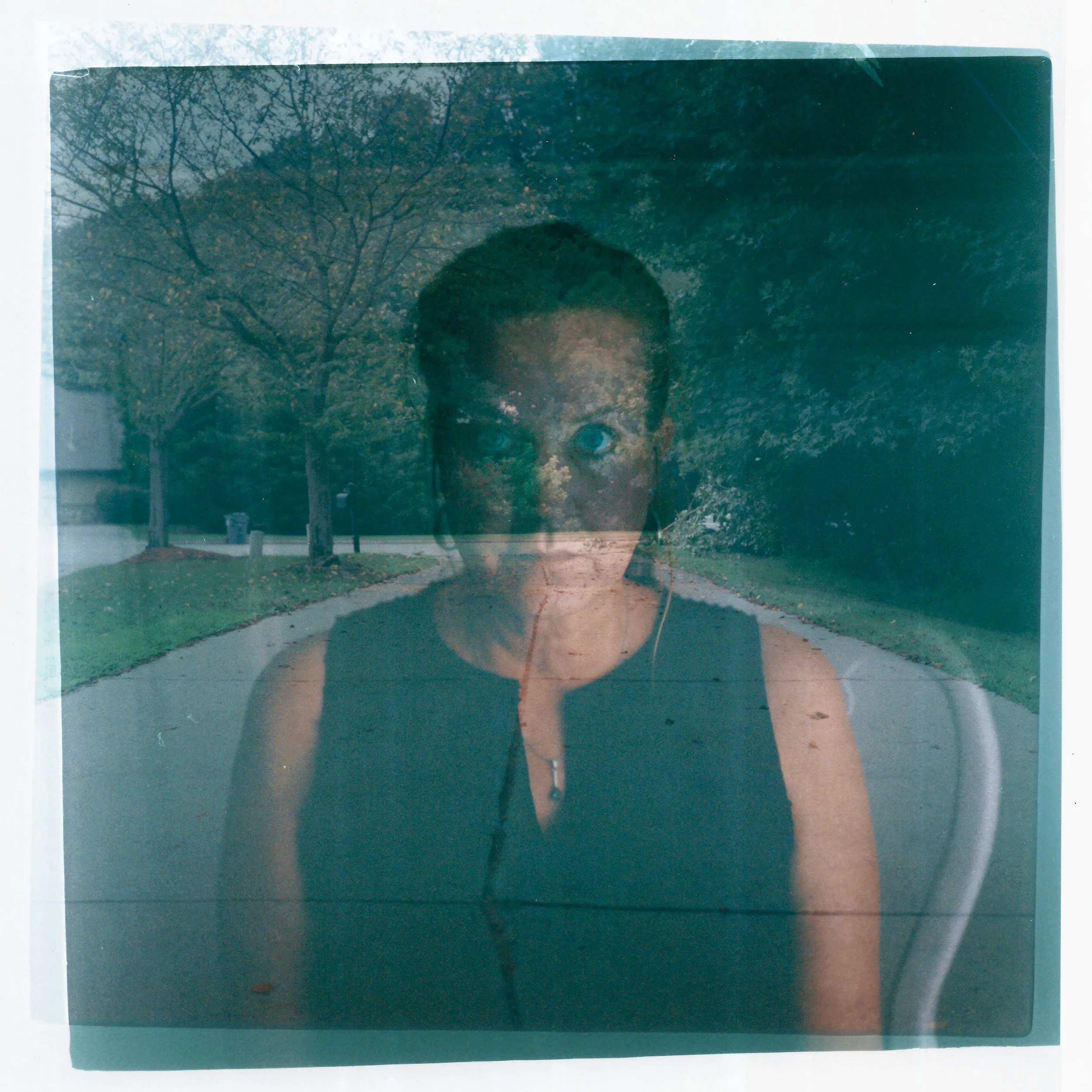 A double exposure made from  headshot of Janet Paulsen layered with a photo of a driveway.