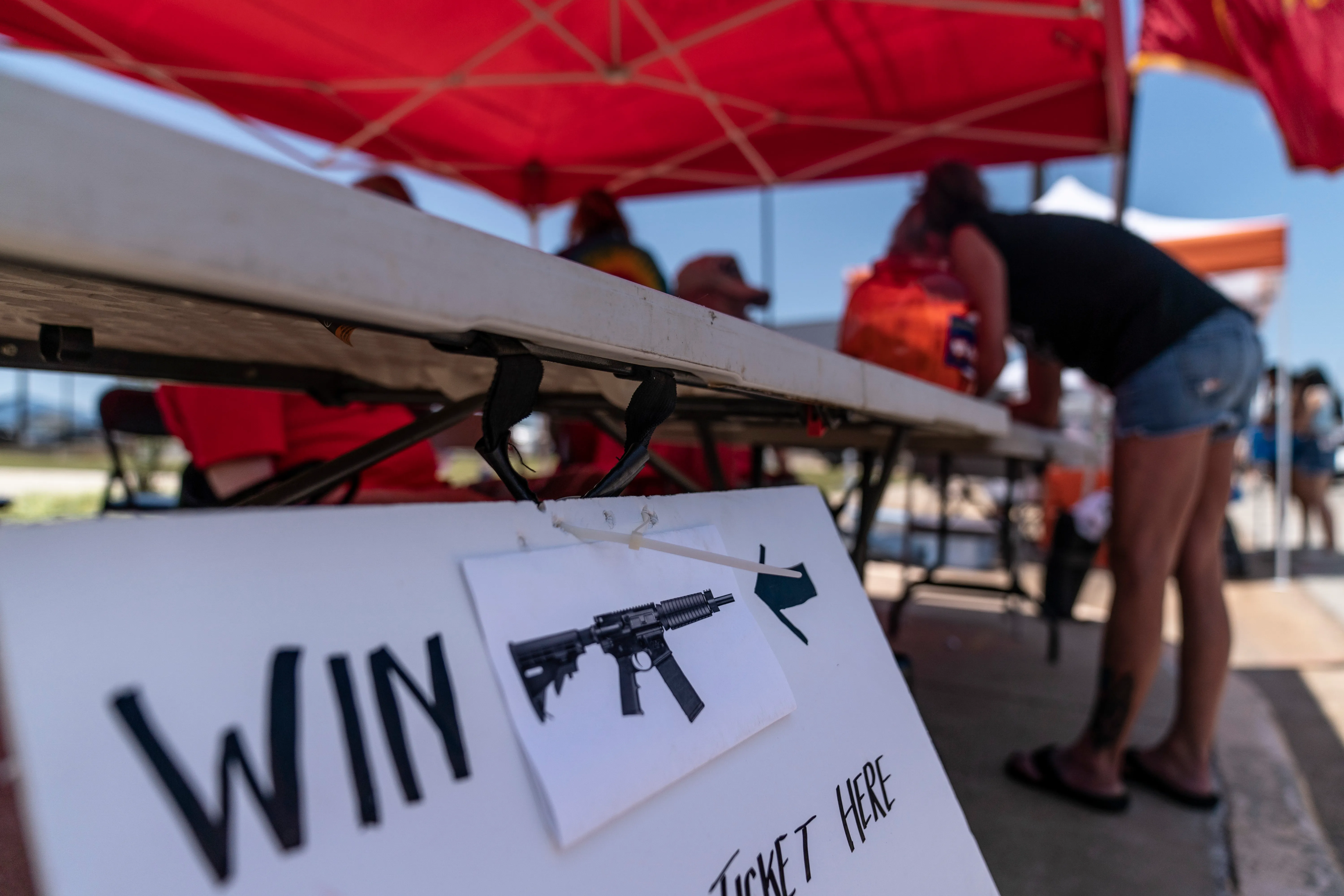 A raffle stand with a sign showing that an AR-15 is the prize. 