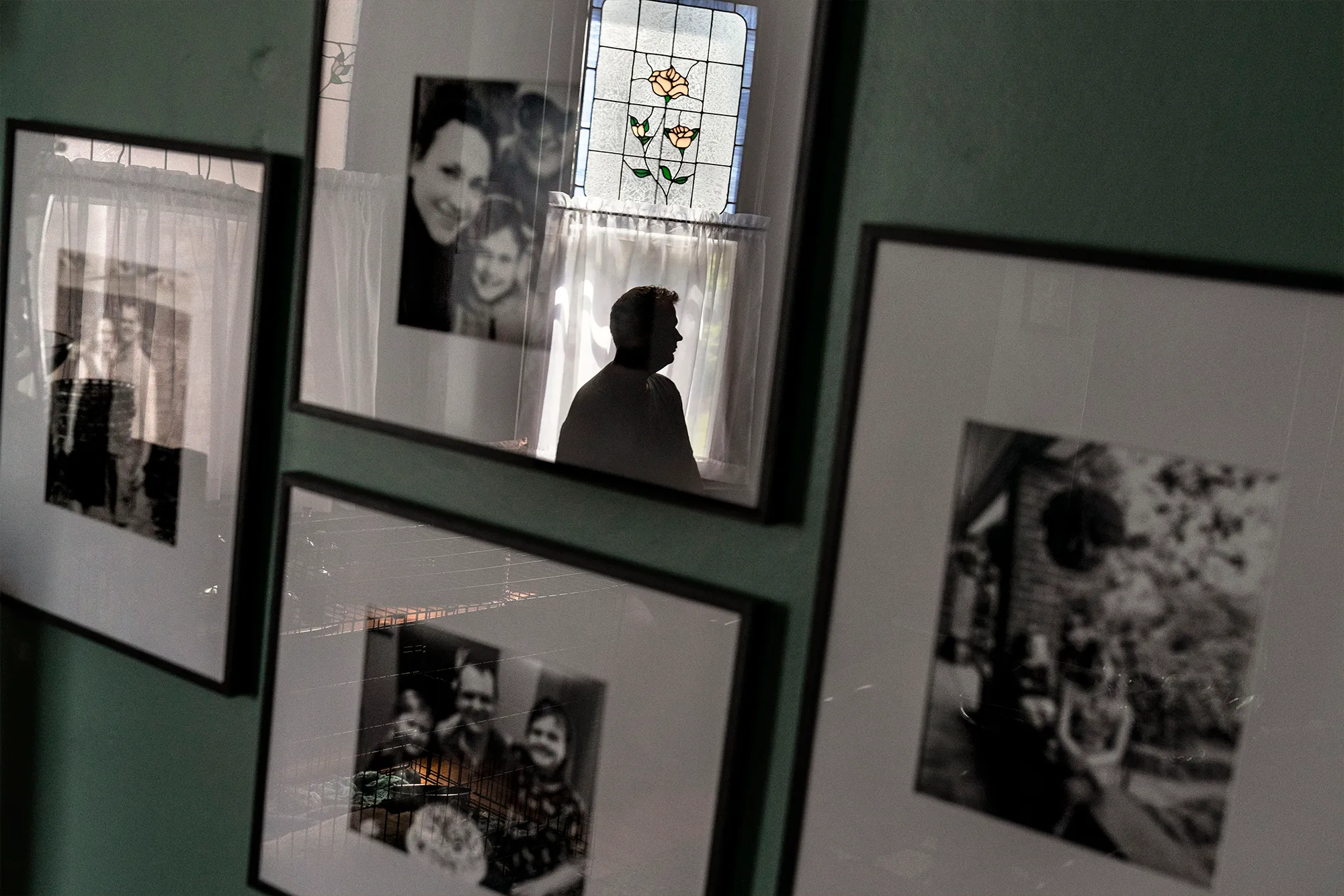 Several frames with family photos hanging on a wall.