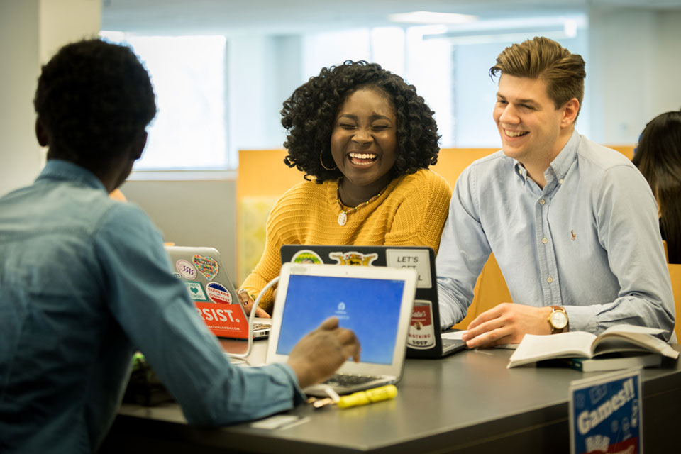 Two students sitting at a table laughing