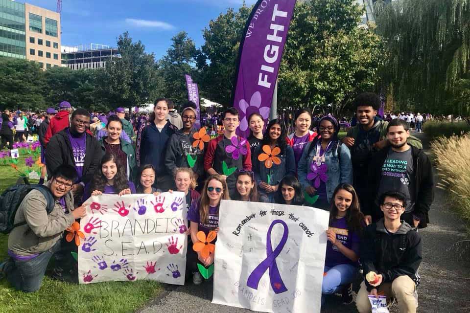 Students hold posters at a benefit walk