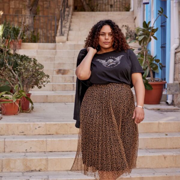 Weibliches Plus Size Model in luftigen Muster-Rock und T-Shirt