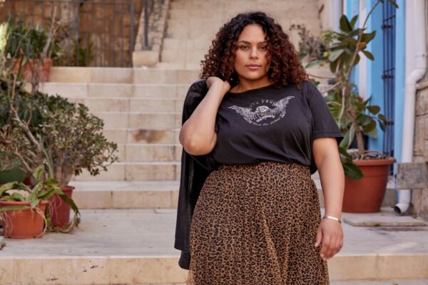 Weibliches Plus Size Model in luftigen Muster-Rock und T-Shirt