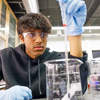 Abhi Karri checks the temperature on a beaker of water.