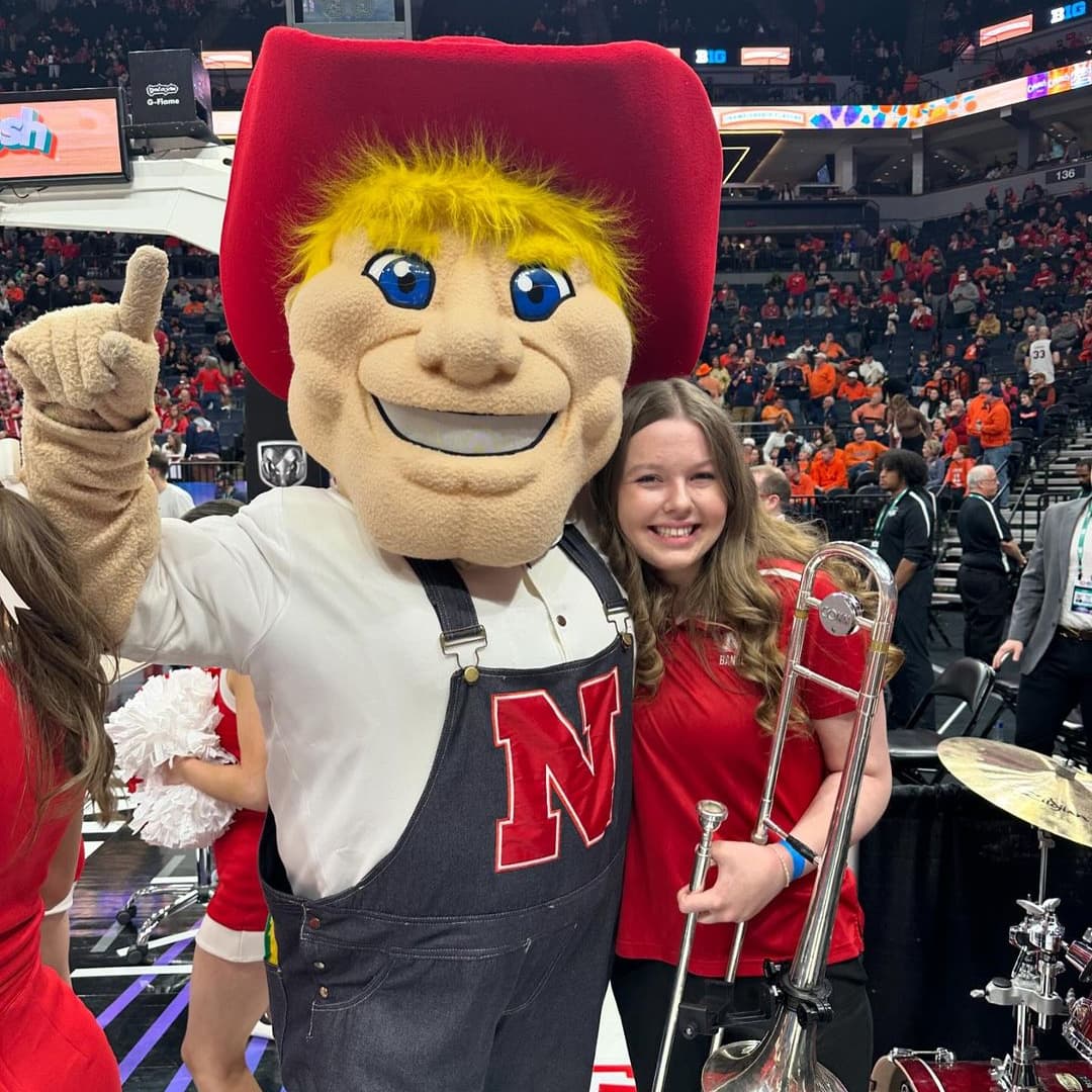 A Husker trombonist poses with Herbie Husker.